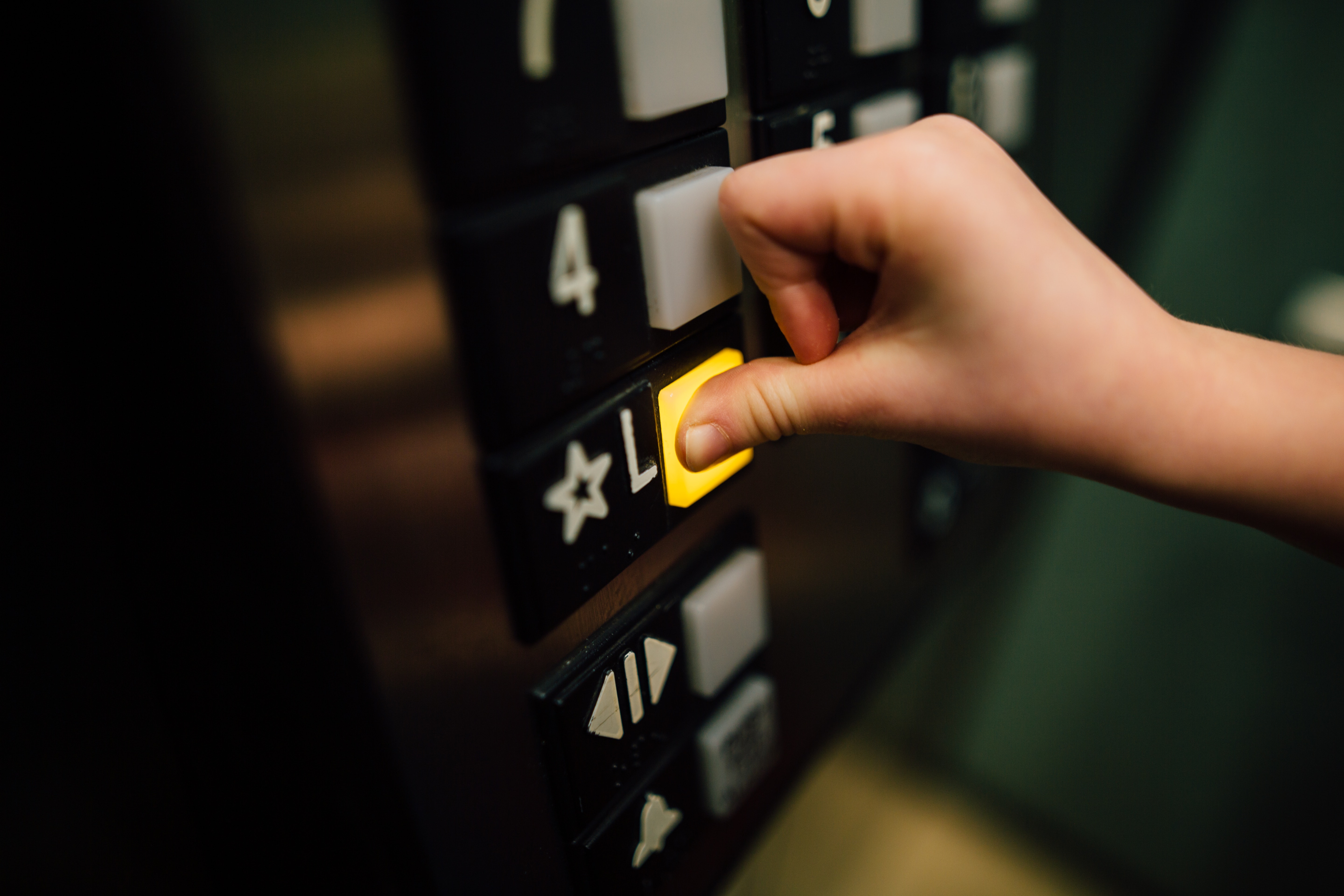 finger pressing a button on a lift powered by a ups system